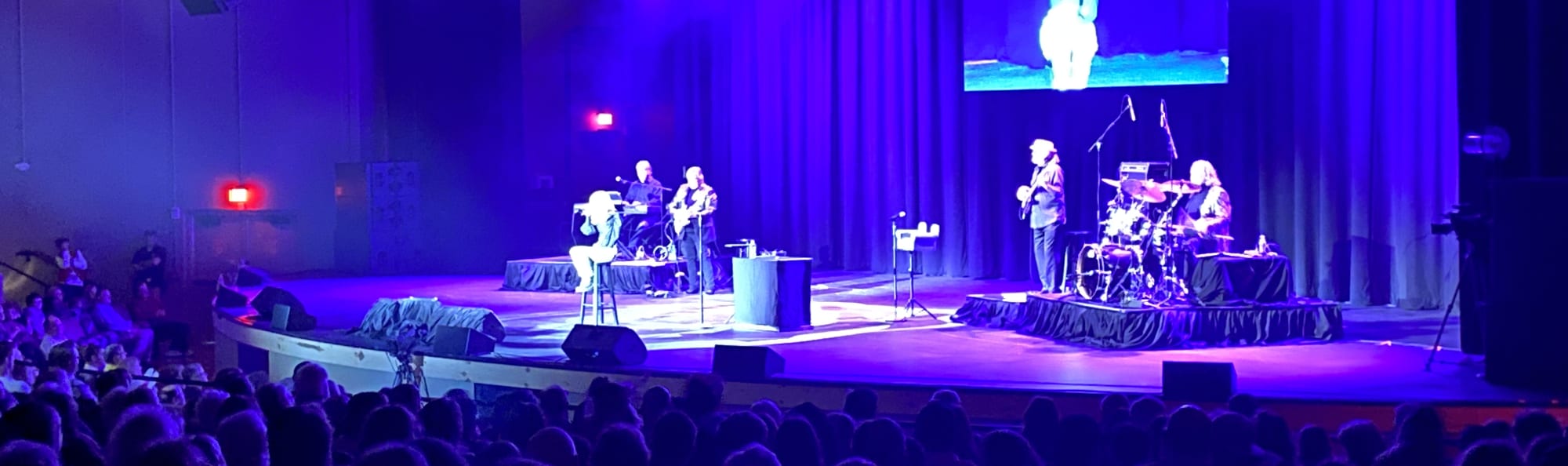 signer on stage in chair washed out by the lights Fort Wayne